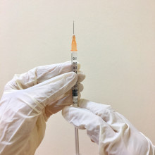 A vaccine being prepared by gloved hands