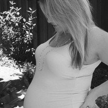 A heavily pregnant woman. Notice the arch in her lower back. At this time in pregnancy she will be experiencing back strain from the heavy weight she is carrying.