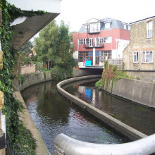 River Wandle, Strathville Rd, SW18. From a road bridge, with some new flats built over the river.