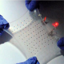 Thin, stretchable battery providing power to a red light emitting diode while deformed biaxially to a strain of ~300%