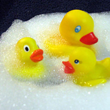 Three yellow rubber ducks play in the bubble bath!